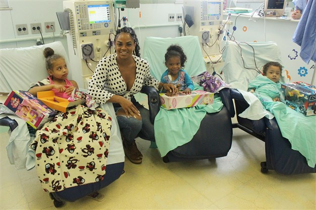 Rainha de bateria da Portela distribui presentes para crianças em hospital 